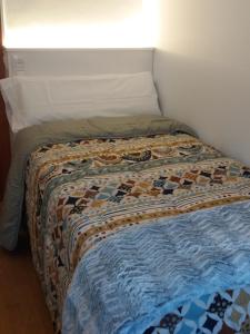 Bett mit einer Decke auf dem Zimmer in der Unterkunft Apartament Gredera in Olot