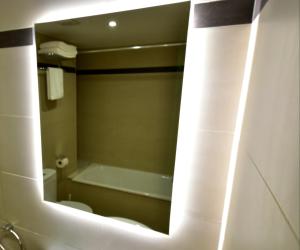 a bathroom with a tub and a sink and a mirror at Apartament Gredera in Olot