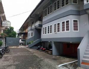 ein Gebäude mit einem Motorrad, das davor geparkt ist in der Unterkunft Maven Cilandak in Jakarta