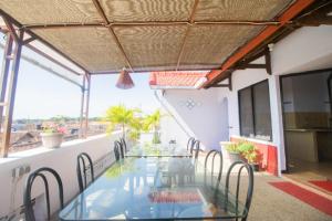 a balcony with a glass table and chairs at RedDoorz near Pantai Boom in Banyuwangi