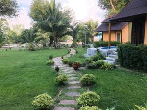 Mook Tamarind Resort في كو موك: حديقة بها مسار حجري في العشب