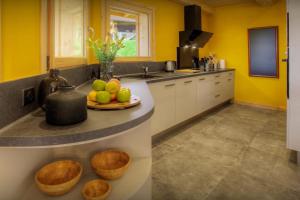 a kitchen with yellow walls and a plate of fruit on a counter at Chalet Marinaka - OVO Network in Manigod