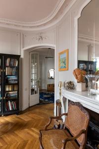 a living room with a chair and a fireplace at Veeve - Haussmann Beauty in the 6th in Paris