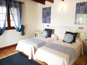 2 Betten in einem Zimmer mit blauen Fenstern in der Unterkunft Rural Rugama in Puerto del Rosario