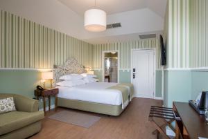 a hotel room with a bed and a couch at Pestana Churchill Bay in Câmara de Lobos