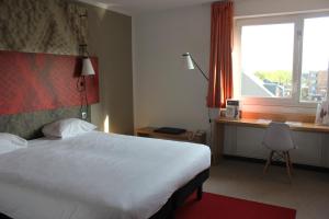 Una cama o camas en una habitación de ibis Mons Centre Gare