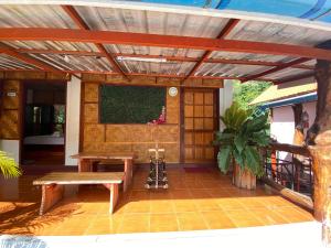 eine Terrasse mit einem Holztisch und einer Bank in der Unterkunft Yayee Homestay in Sai Yok