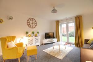 a living room with a yellow chair and a tv at Central, Stylish 2-bed Apartment, with allocated parking in Wakefield