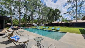 a swimming pool with lounge chairs and a swimming pool at Origin Uluwatu in Uluwatu