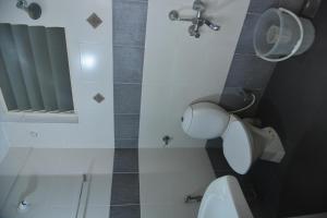 ein Bad mit einem WC und einem Waschbecken in der Unterkunft Emporium Hotel in Mangaluru