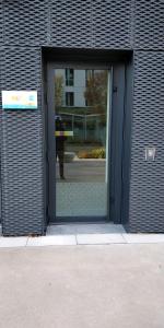 une porte menant à un bâtiment avec une personne qui le traverse dans l'établissement @Coloc Gîtes urbains, à Nantes
