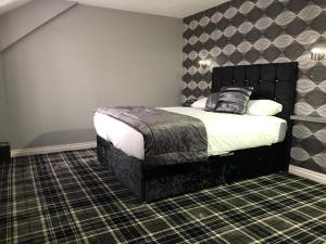 um quarto com uma cama com uma cabeceira preta em The Birmingham Hotel em Birmingham