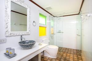 La salle de bains est pourvue d'un lavabo, de toilettes et d'une douche. dans l'établissement Phusanfah Resort, à Mae Taeng