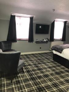 a hotel room with a bed and a chair and window at The Birmingham Hotel in Birmingham