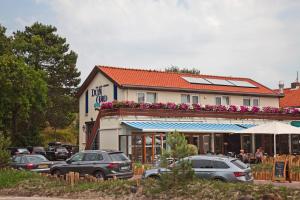 a restaurant with cars parked in front of a building at Budget Hotel Vrouwenpolder in Vrouwenpolder