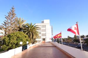 a bridge over a street with flags in front of a building at Sud Bahia Agadir "Bahia City Hotel" in Agadir