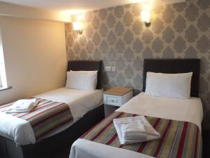 two beds in a hotel room with two beds sidx sidx sidx at The Fazeley Inn in Fazeley