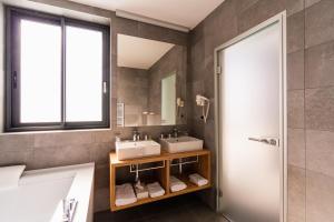 a bathroom with two sinks and a mirror at Hotel Olea in Novalja
