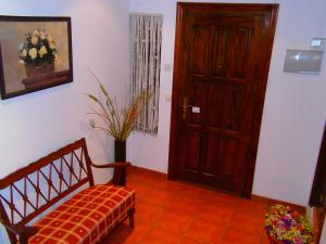 a room with a door and a bench with a flower vase at Apartamentos El Brezo in Albarracín