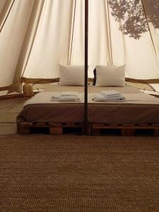 a bed in a tent with two pillows on it at Monte da Tojeirinha in Montargil