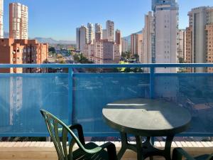 a table and chairs on a balcony with a view of a city at BENIDORM CENTER KENNEDY APARTMENT in Benidorm