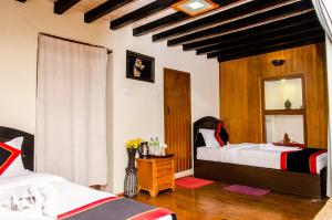 a bedroom with two beds and a mirror at Tulaja Boutique Hotel in Bhaktapur
