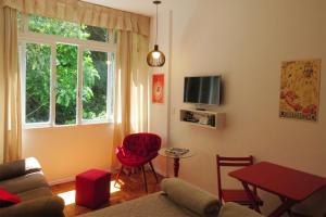 a living room with a couch and a table and a window at Studio 14 in Petrópolis