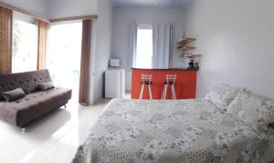 een slaapkamer met een bed en een bank bij Chalés Aconchego in Cavalcante