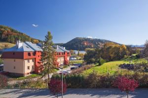 a row of houses on a hill with a mountain at PRESTIGE PARK Apartament MINI z parkingiem in Krynica Zdrój