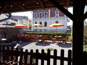 eine Terrasse mit Tischen, Stühlen und Sonnenschirmen in der Unterkunft Fewo Am Triebischbrunnen in Meißen