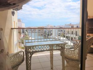 a balcony with a table and chairs and a view of a river at Magnífico apartamento junto al canal principal. in Empuriabrava