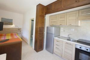 a kitchen with wooden cabinets and a stainless steel refrigerator at Un Nido sul Mare - Goelba in Portoferraio