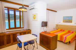 una camera con letto, scrivania e tavolo di Un Nido sul Mare - Goelba a Portoferraio