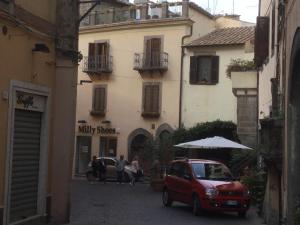 Un coche rojo aparcado delante de un edificio en Viterbo centro Casa Surina, en Viterbo