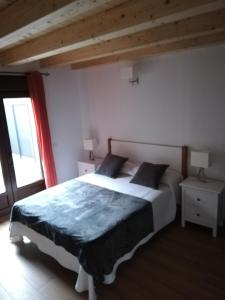 une chambre avec un grand lit et une fenêtre dans l'établissement Puente viejo de Buitrago casa Fresno, à Buitrago del Lozoya