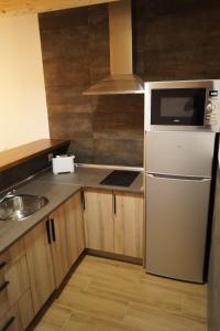 a kitchen with a white refrigerator and a sink at Puente viejo de Buitrago casa Fresno in Buitrago del Lozoya