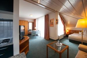 een hotelkamer met een bed en een woonkamer bij Residenz Royal in Sandhausen