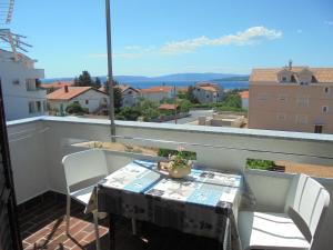 a table and chairs on a balcony with a view at Apartments Mrak in Punat