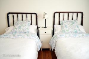 a bedroom with two beds and a night stand at Chalet Las Calzadas - Jardín, parking y vistas increíbles in San Vicente de la Barquera