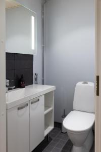 a white bathroom with a toilet and a sink at Apartment Loimu C75 in Rovaniemi