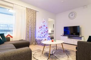 a living room with a christmas tree and a couch at Apartment Loimu C75 in Rovaniemi +7 photos