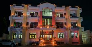 duży biały budynek z samochodem zaparkowanym przed nim w obiekcie Hotel Narayan Palace w mieście Amarsar