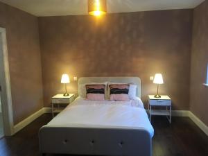 sypialnia z białym łóżkiem i 2 szafkami nocnymi w obiekcie Wainsfort House w mieście Blacklion