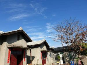 una casa con puertas rojas y un cielo azul en ZYIN Homestay en Kaohsiung