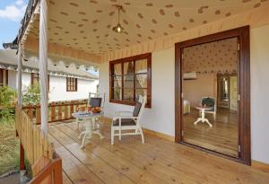 porche con mesa, sillas y puerta corredera de cristal en Jawai Leopard Safari Lodge, en Bera
