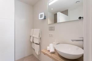 a white bathroom with a sink and a mirror at B&B - Brasserie De Lindeboom in Serooskerke