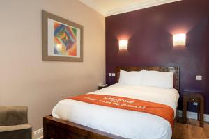 1 dormitorio con 1 cama y una pintura en la pared en Amsterdam Hotel Brighton Seafront, en Brighton & Hove