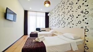 a hotel room with two beds and a tv at Plaza Inn Batumi in Batumi