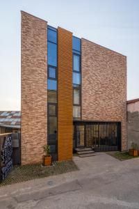 a tall brick building with a large window at Tbilisi Story Hotel in Tbilisi City