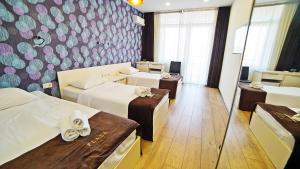 a hotel room with three beds and a mirror at Plaza Inn Batumi in Batumi +94 photos